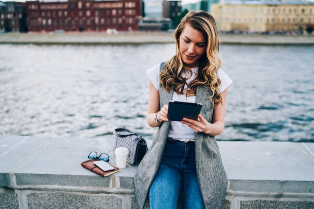 Gorgeous positive female person watching interesting video in webpage during recreating outside