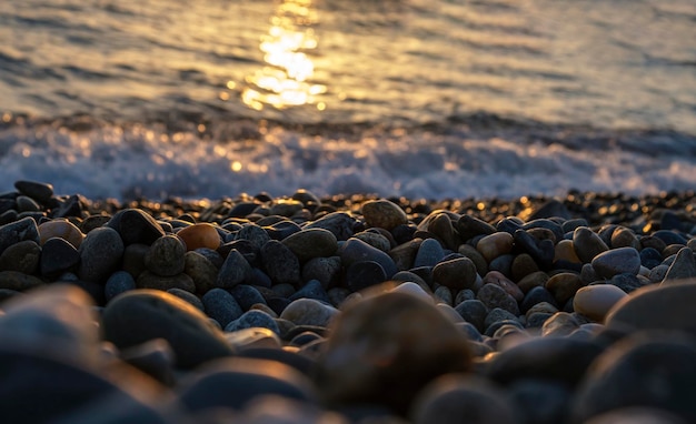 Gorgeous sea sunset landscape MIrror reflection of dawn on wet pebble Golden sunlight over sea waves Close up of tide foam and sea pebble coast