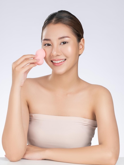 Gorgeous woman applying her cheek with dry powder