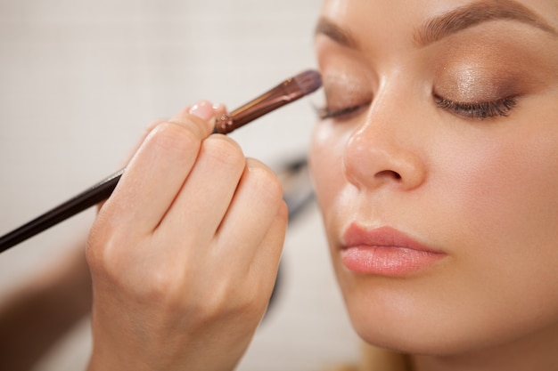 Gorgeous woman getting professional makeup