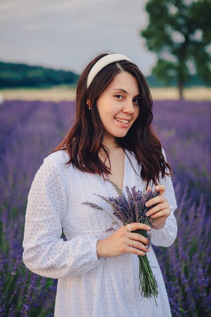 Gorgeous woman in white dress at lavender field sunset time