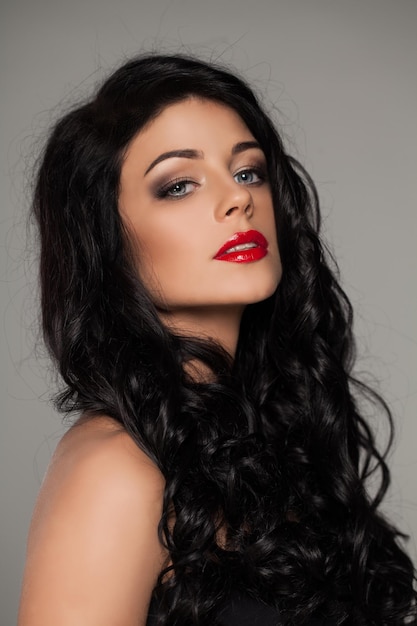 Gorgeous Woman with Dark Curly Hair and Red Lips Makeup