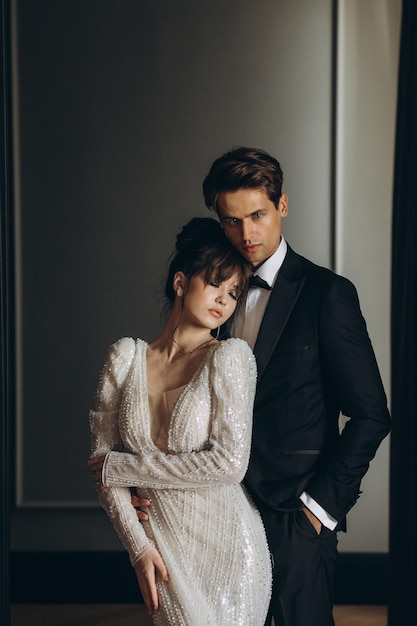 Gorgeous woman with red lips and big eyes stands with man in hotel room