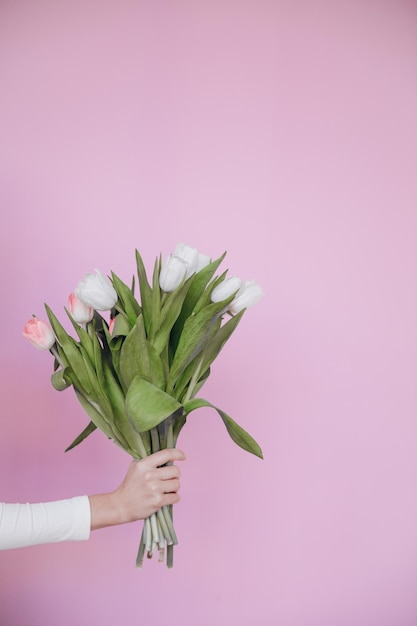 Gorgeous young lady feeling excited to receive bunch of tulips for Woman's Day