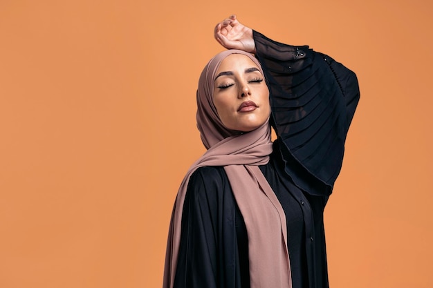 Gorgeus muslim woman closing her eyes posing in studio. She's serious.