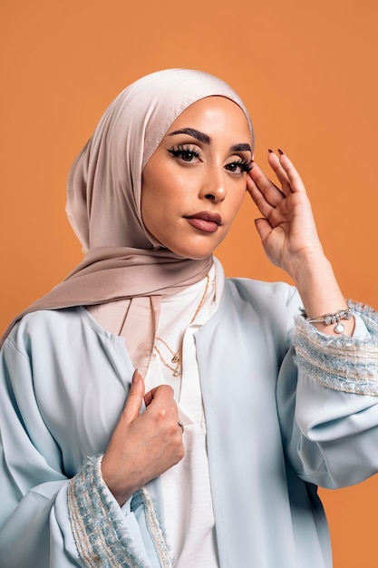 Gorgeus muslim woman looking at camera posing in studio. She's serious.