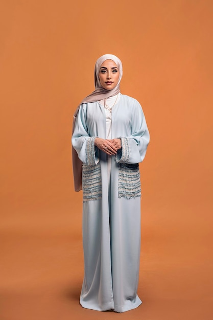 Gorgeus muslim woman looking at camera posing in studio. She's serious.