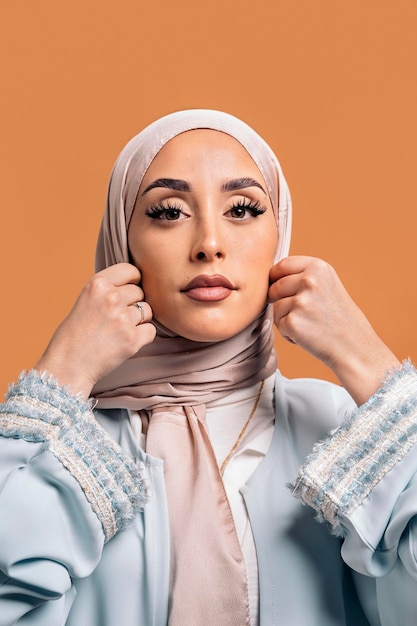 Gorgeus muslim woman looking at camera posing in studio. She's serious.