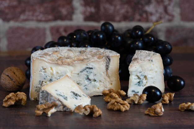 Gorgonzola blue mold cheese with grapes and nuts. Handmade.