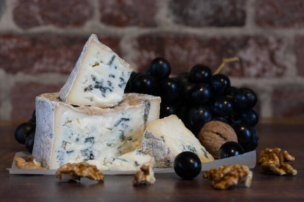 Gorgonzola blue mold cheese with grapes and nuts. Handmade.