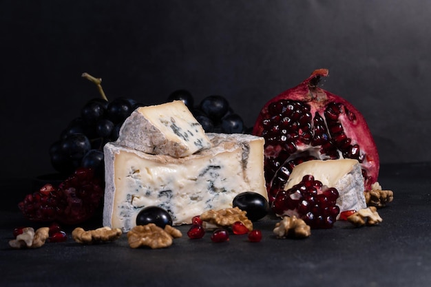 Gorgonzola blue mold cheese with pomegranate, grapes and nuts.