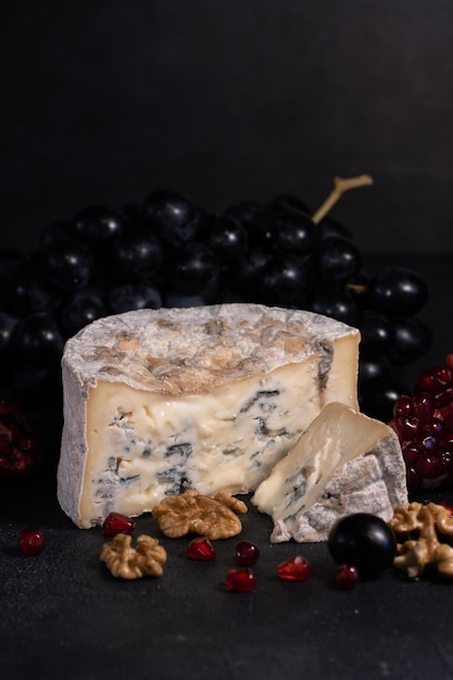 Gorgonzola blue mold cheese with pomegranate, grapes and nuts.