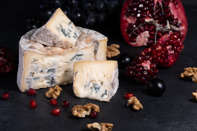 Gorgonzola blue mold cheese with pomegranate, grapes and nuts.