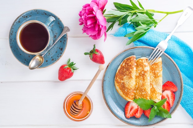 Gourmet breakfast. Delicious sweet fried pancakes with fresh strawberries.