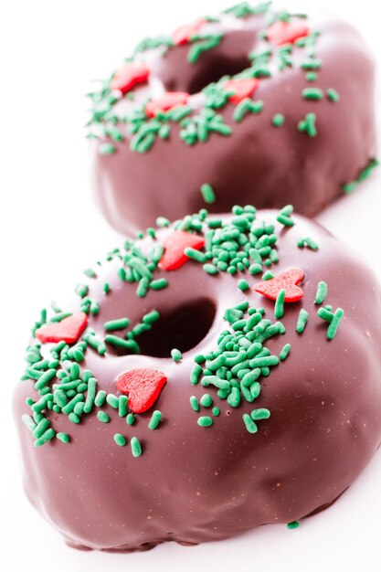 Photo gourmet chocolate covered doughnut decorated as a christmas wreath.