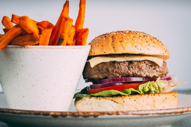 Gourmet juicy burger with a side of sweet potato fries