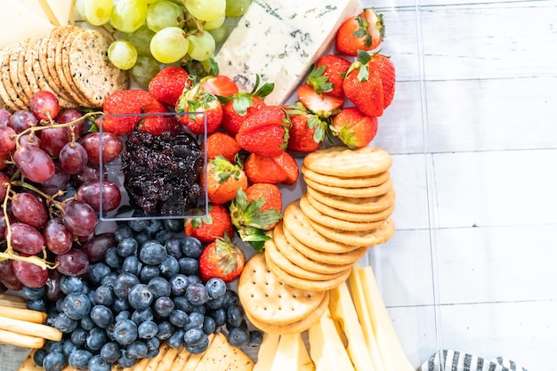 Gourmet party cheese platter with fruit, cheese, and crackers.