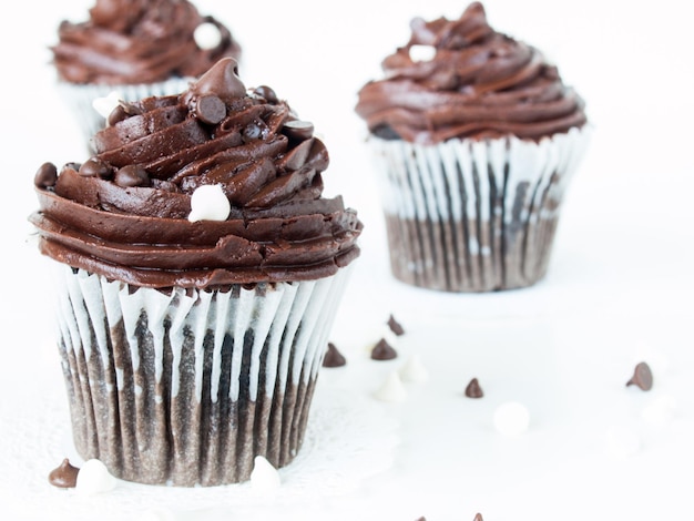 Gourmet quadruple chocolate cupcakes on white background.