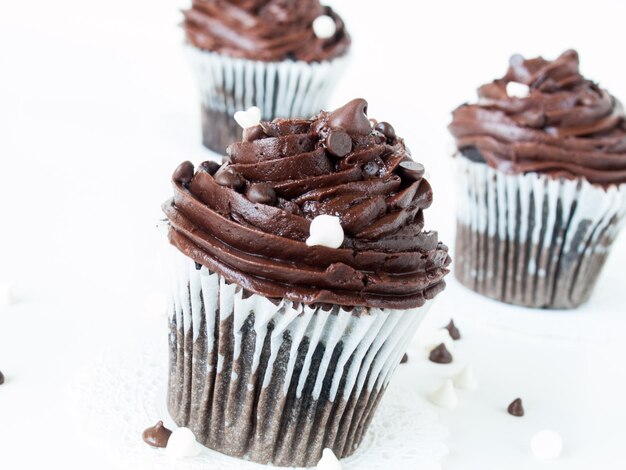 Gourmet quadruple chocolate cupcakes on white background.