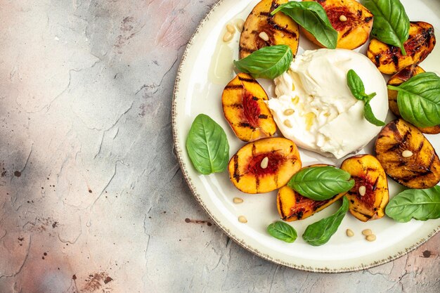 Gourmet Roasted Peaches with Burrata soft cheese basil and drizzled with honey with rose wine Antipasto Dinner or aperitivo party