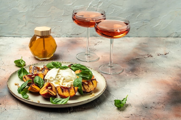 Gourmet Roasted Peaches with Burrata soft cheese basil and drizzled with honey with rose wine Antipasto Dinner or aperitivo party