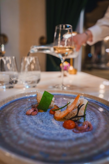 Gourmet seafood dish with white wine in luxury hotel dining setting