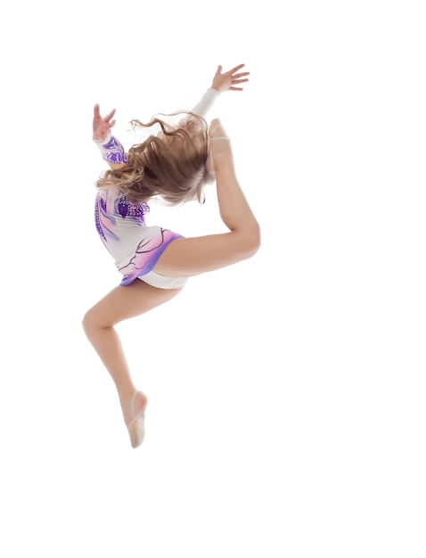 Graceful little artistic gymnast posing in jump