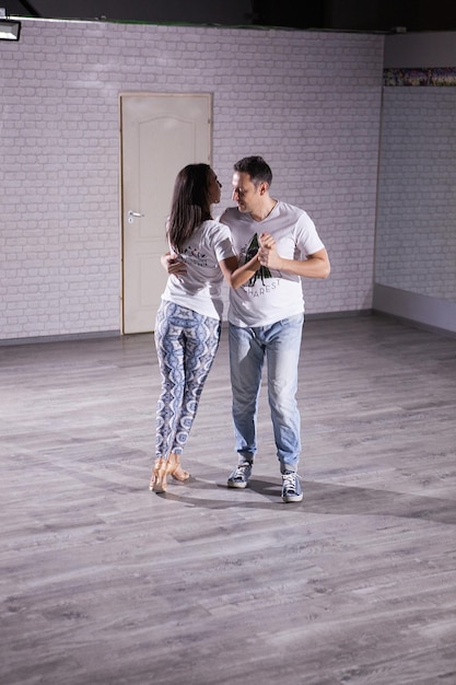 Graceful young couple enjoying social dance kizomba. On their dance class.