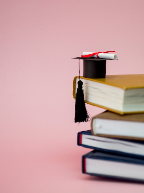 Graduation cap and diploma on different books with copy space