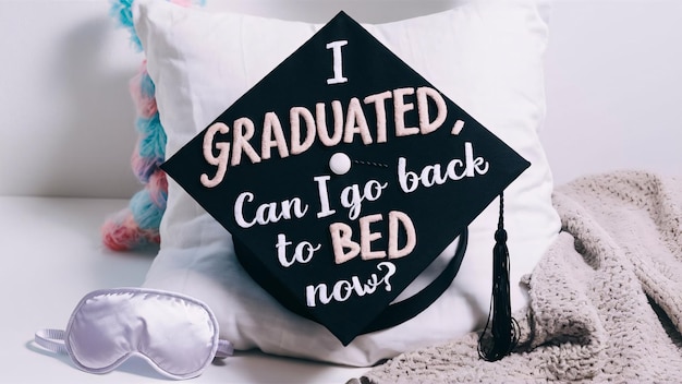 A Graduation cap with the words I Graduated Can I go back to bed now in playful typography