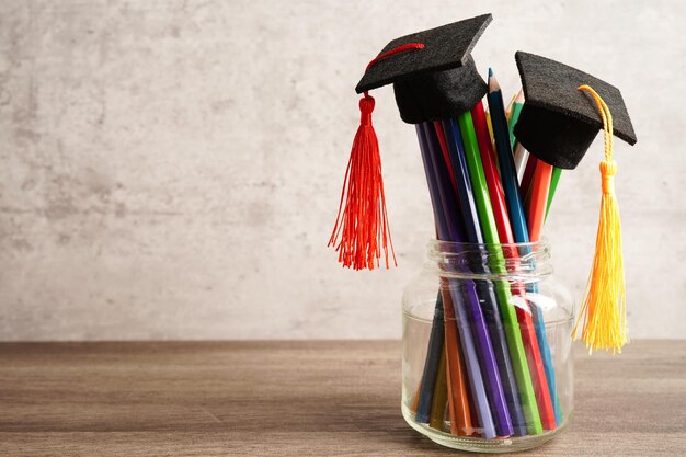 Graduation hat with colorful pencils on book with copy space learning university education concept