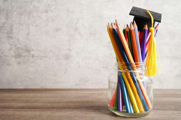 Graduation hat with colorful pencils on book with copy space learning university education concept