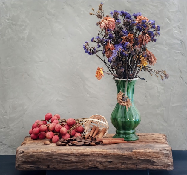 Grain and dried flowers in green vase with still life