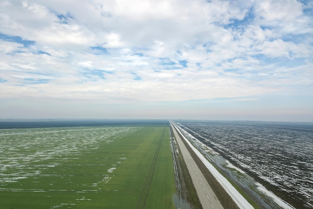 Grain field covered by snow in spring Aerial View.