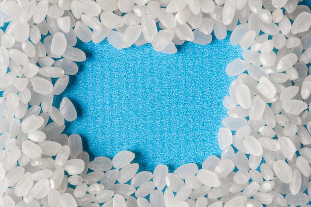 Grains of rice grit on a blue background. A healthy diet. A place for text.