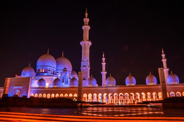 Grand Mosque in Abu Dhabi at night. Panoramic view of exterior of Sheikh Zayed Mosquein UAE with epic lightening.