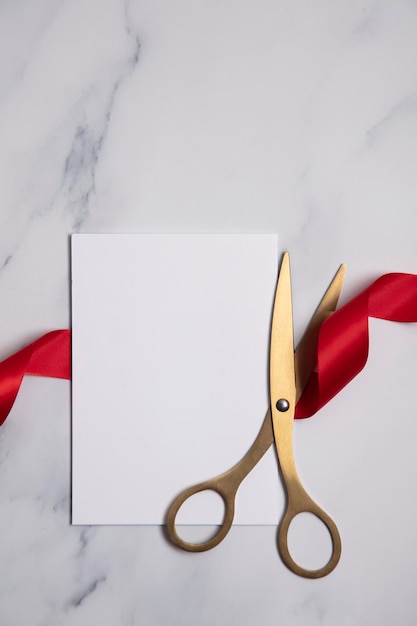 Grand opening background Gold scissors with red ribbon on a marble background