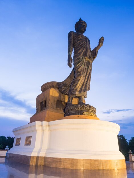 Grand walking buddha bronze statue in Phutthamonthon Buddhist province Thailand in twilight time