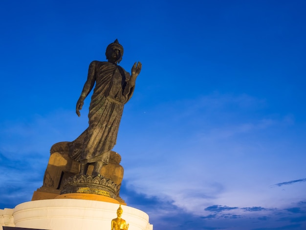 Grand walking buddha bronze statue in Phutthamonthon Buddhist province Thailand in twilight time