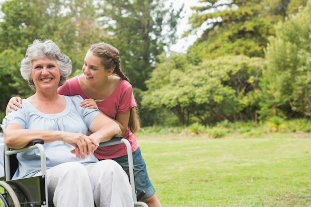 Granddaughter embracing grandmother in wheelchair