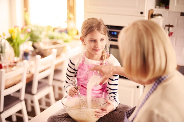 Granddaughter and grandmother with baking equipment