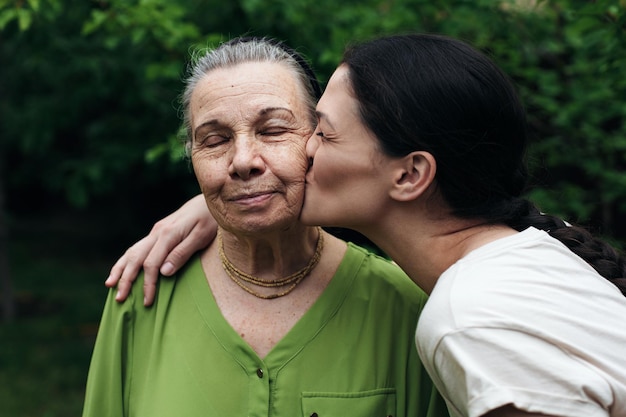 Granddaughter kissing her grandmother in the garden