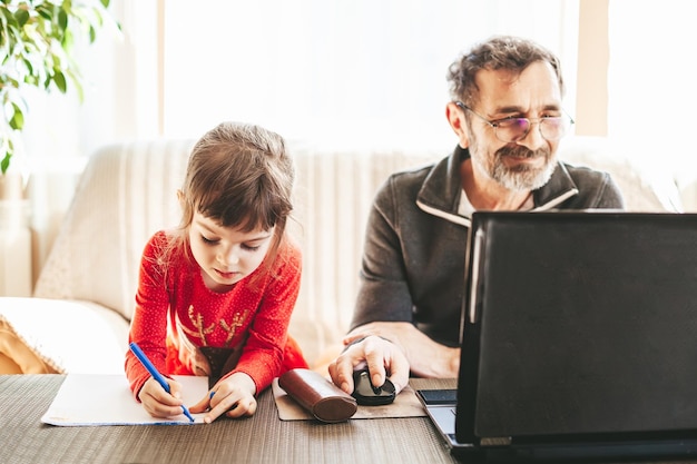 Grandfather and granddaughter doing their own things