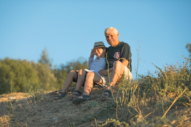 Grandfather and grandson enjoying outdoor smiling and hugging Concept of friendly family