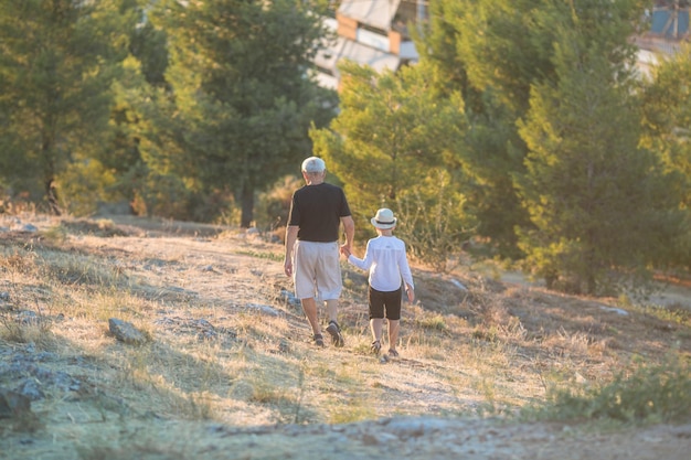 Grandfather and grandson enjoying outdoor smiling and hugging Concept of friendly family