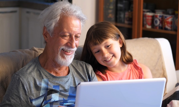 Grandfather and grandson talk and greet by making a video call to the pc