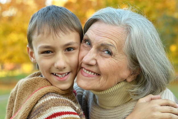 Grandfather and grandson together in autumn park