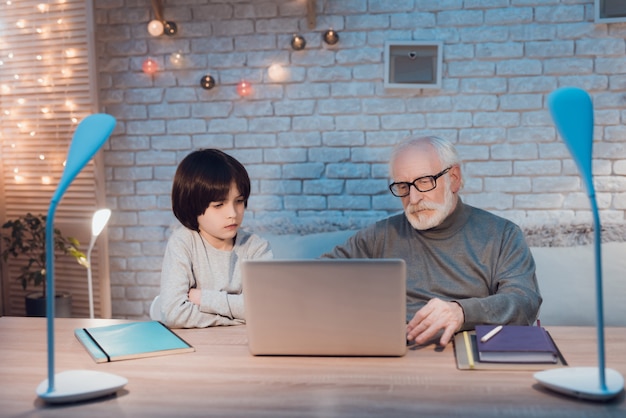 Grandfather and Grandson Using Laptop Together