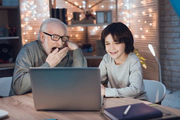 Grandfather and Grandson Watching Movie on Laptop