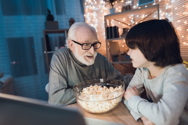 Grandfather and Grandson Watching Movie on Laptop